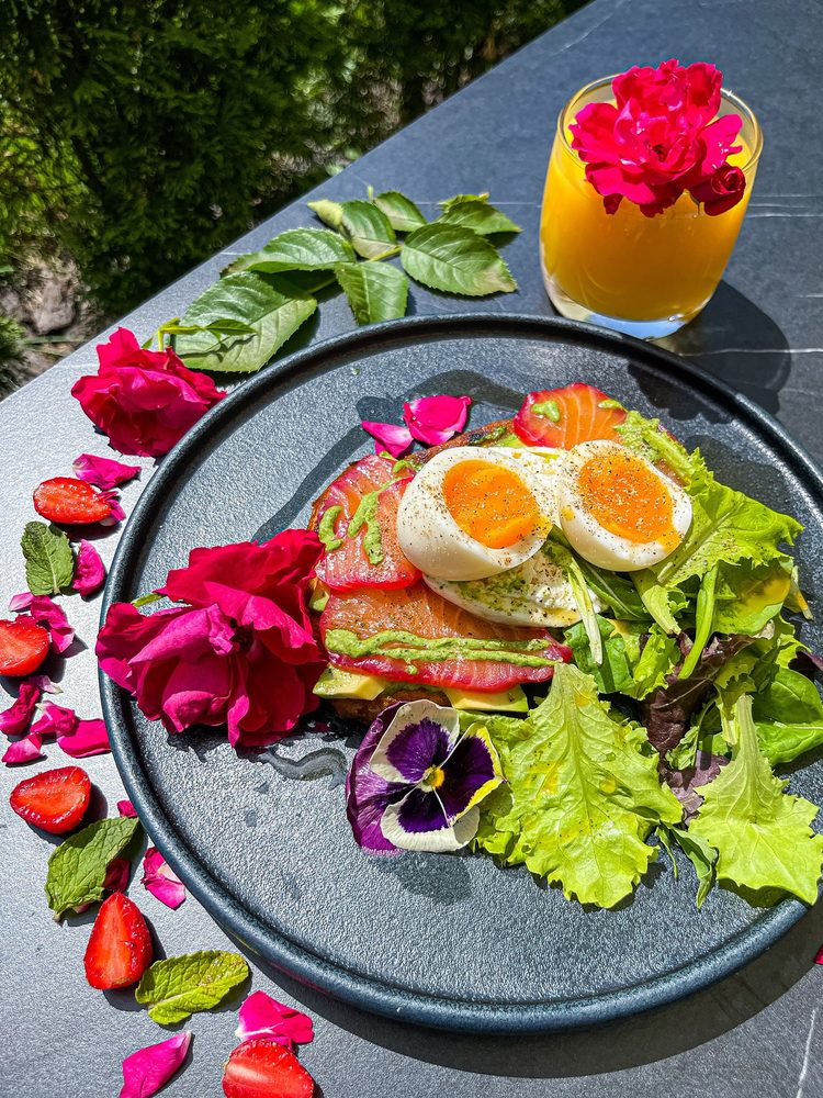 Eggs, salad and flowers on a dark plate