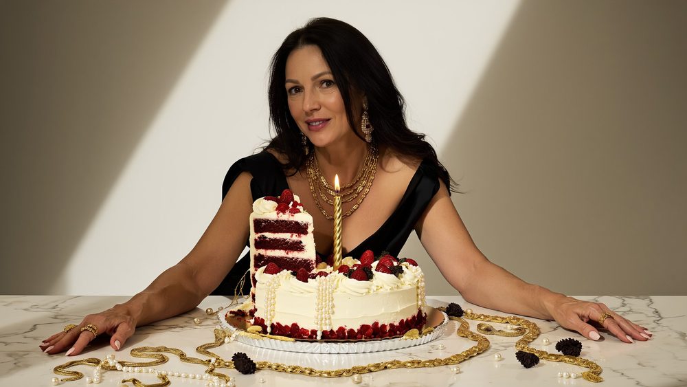 Woman at a marble table with a birthday cake